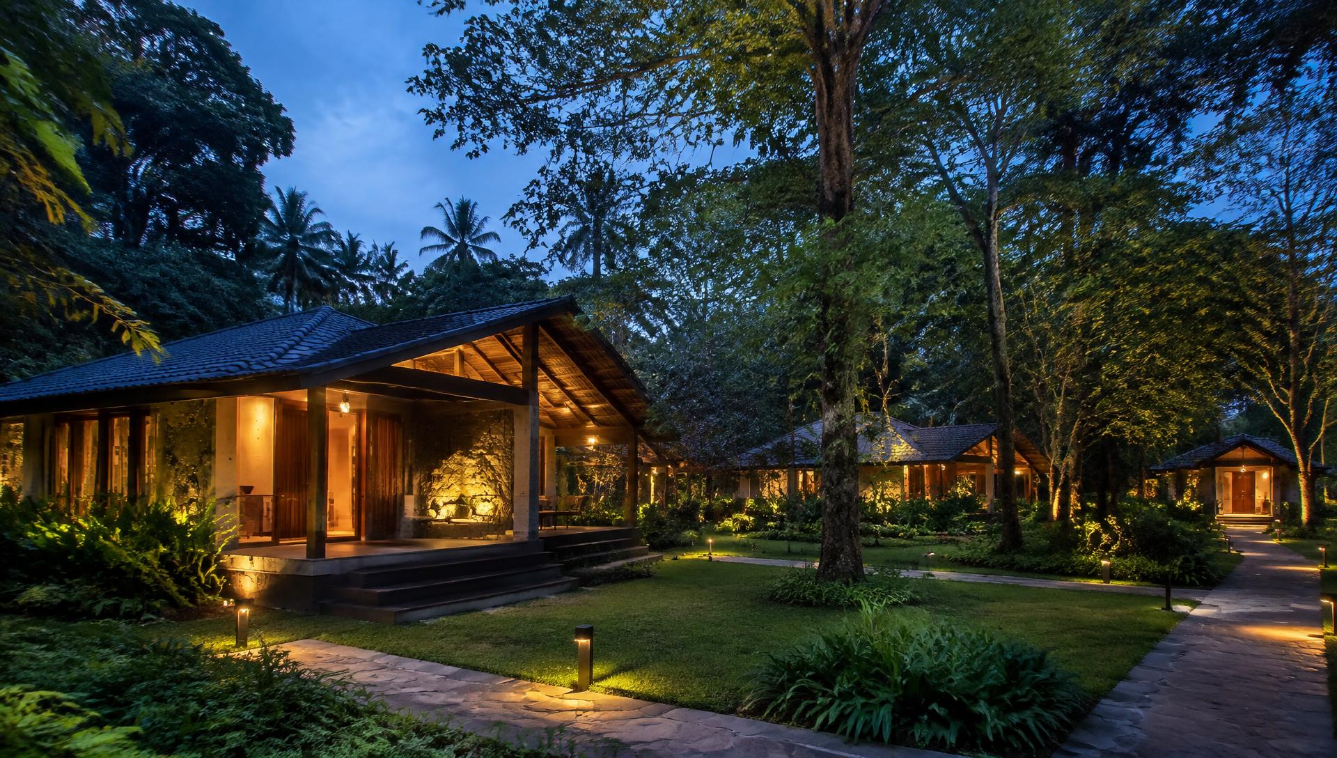 The Woods Maredumilli resort cottages surrounded by forest at dusk